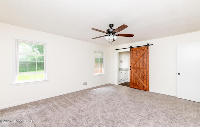 4002 Ciremos Ter, Louisville, KY 40241 - unfurnished bedroom with a barn door, carpet, baseboards, and connected bathroom