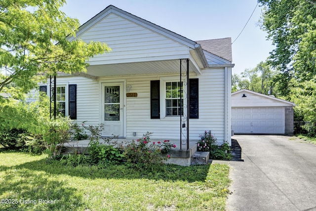 bungalow featuring a garage, an outdoor structure, a shingled roof, a front yard, and covered porch