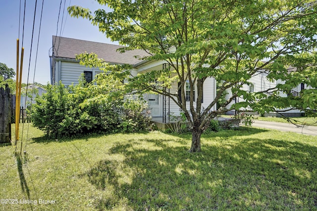 view of front of property featuring a front lawn and a shingled roof