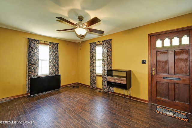 foyer entrance featuring ceiling fan, baseboards, and dark wood-type flooring