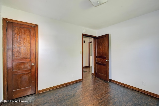 empty room with dark wood finished floors and baseboards
