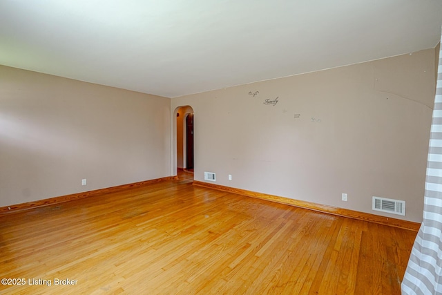 2213 Amboy Dr, Louisville, KY 40216 - spare room featuring arched walkways, light wood-type flooring, and baseboards