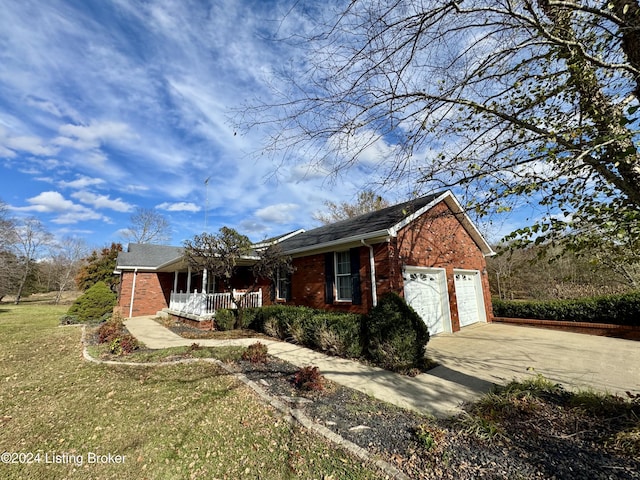 view of front facade featuring a porch, brick siding, driveway, a garage, and a front yard