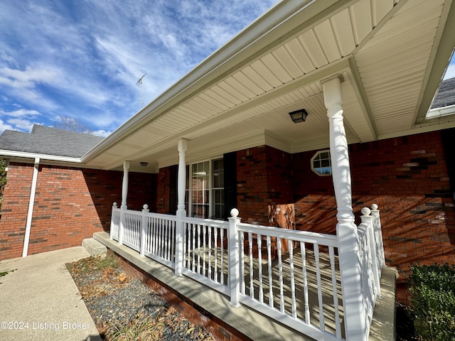 exterior space featuring a porch and brick siding