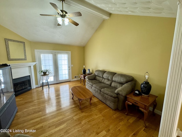 living room with light wood-style flooring, ceiling fan, and vaulted ceiling with beams
