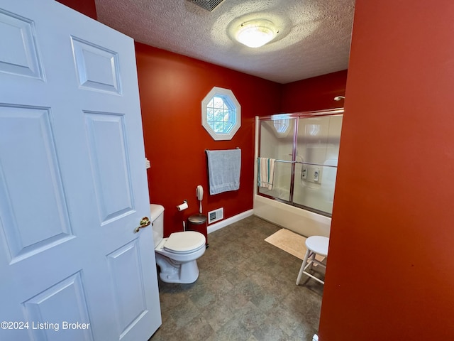 bathroom with toilet, a textured ceiling, visible vents, tile patterned floors, and bath / shower combo with glass door