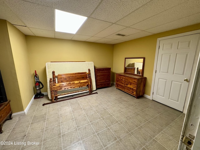 bedroom featuring visible vents, baseboards, and a paneled ceiling