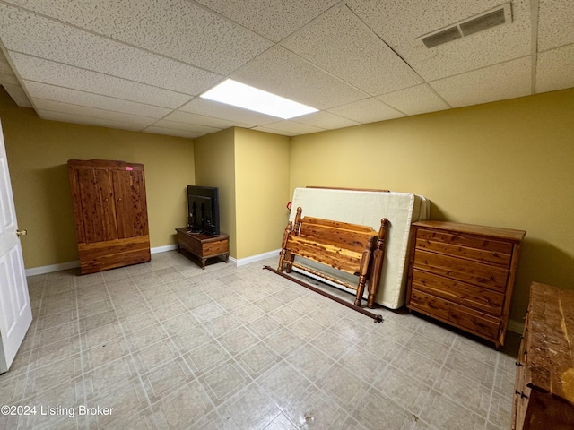 bedroom with a drop ceiling, visible vents, and baseboards