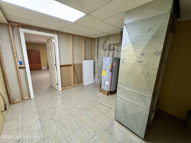 finished basement featuring water heater and a drop ceiling