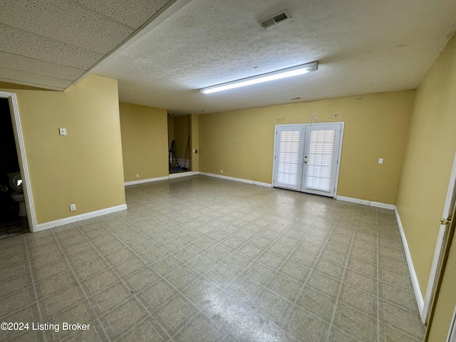 spare room with french doors, visible vents, and baseboards