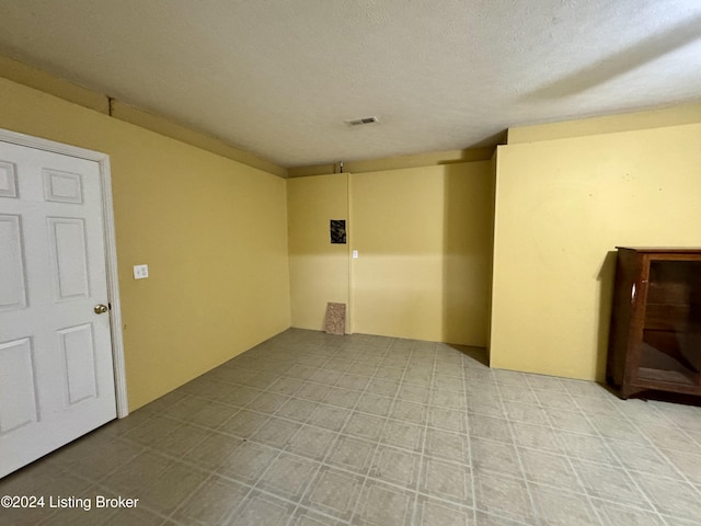 unfurnished room with a textured ceiling and visible vents