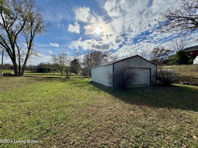 view of yard with a garage and an outbuilding