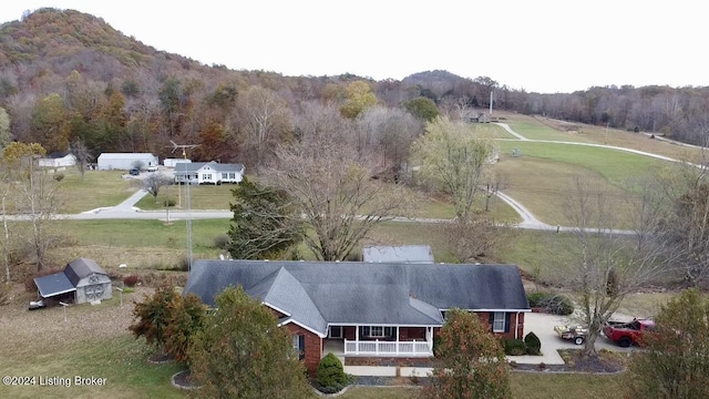 aerial view featuring a wooded view and a mountain view