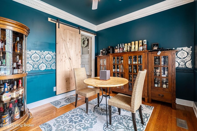 13216 Willow Forest Dr, Louisville, KY 40245 - dining space with wood finished floors, a barn door, ceiling fan, crown molding, and baseboards