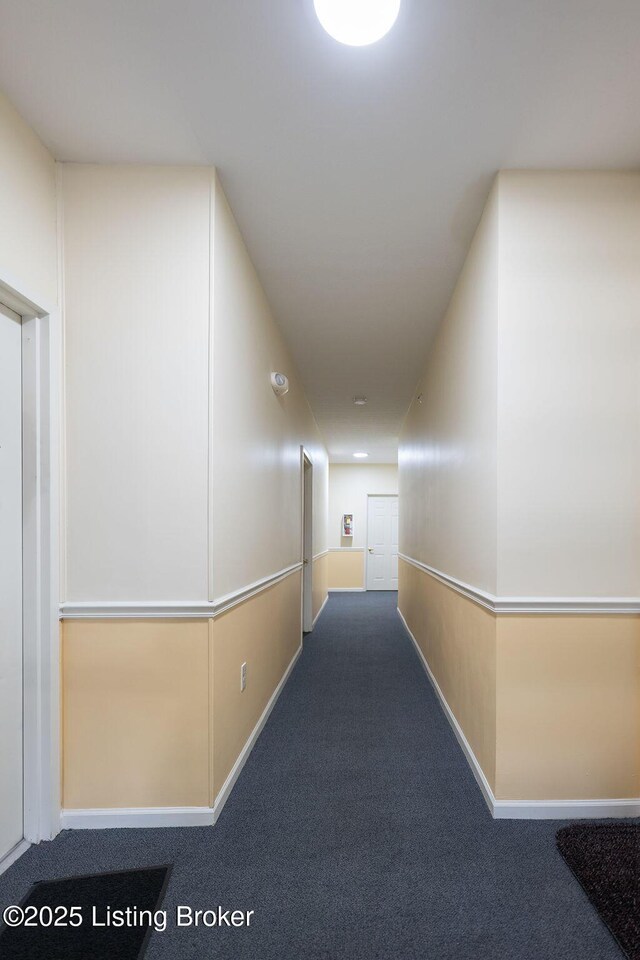 hallway featuring carpet floors and baseboards