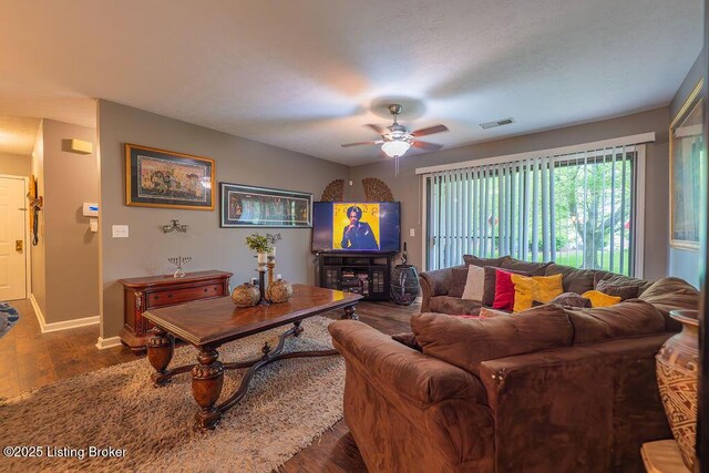 living room with a ceiling fan, dark wood-style floors, and baseboards
