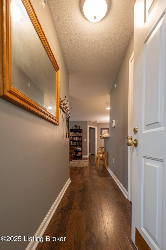 hallway with wood-type flooring and baseboards