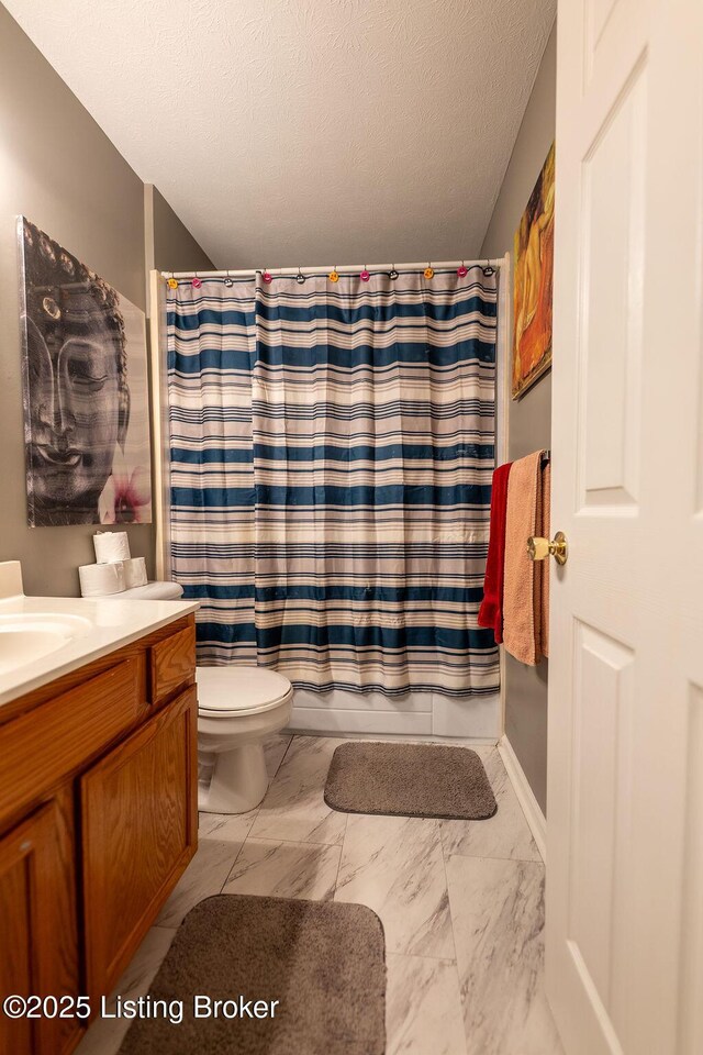 full bath with marble finish floors, vanity, toilet, and a textured ceiling