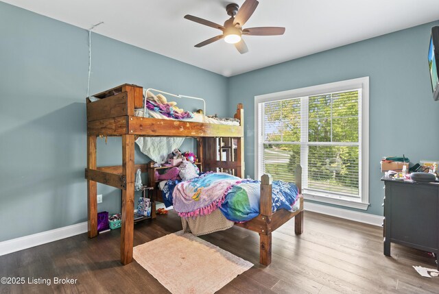 bedroom featuring baseboards, wood finished floors, and ceiling fan