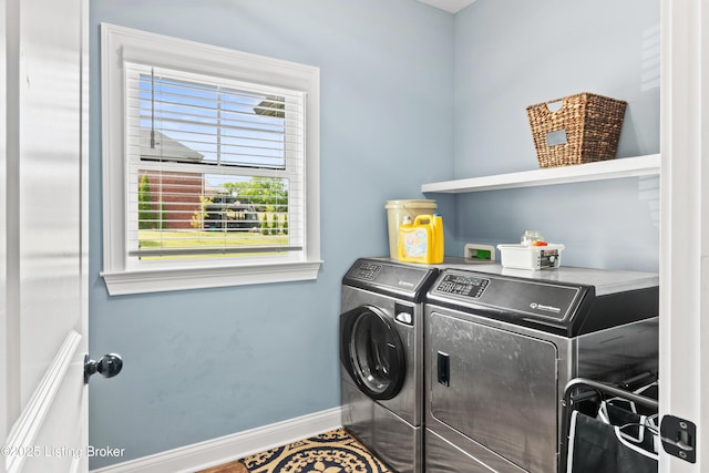 clothes washing area featuring washing machine and dryer and baseboards
