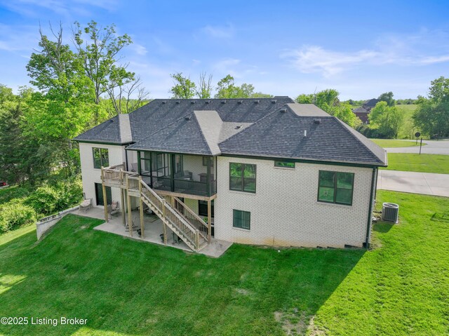 rear view of house with a patio area, a shingled roof, and a lawn