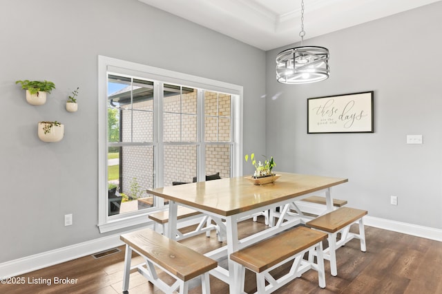 dining area with dark wood-type flooring, baseboards, a chandelier, and crown molding