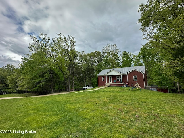 ranch-style home featuring metal roof and a front yard