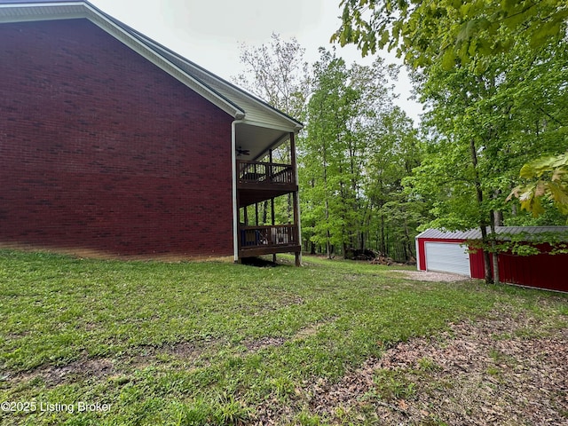 view of yard with a ceiling fan, an outdoor structure, and a detached garage