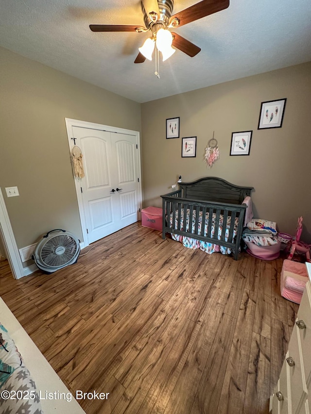 bedroom featuring a closet, wood finished floors, and ceiling fan