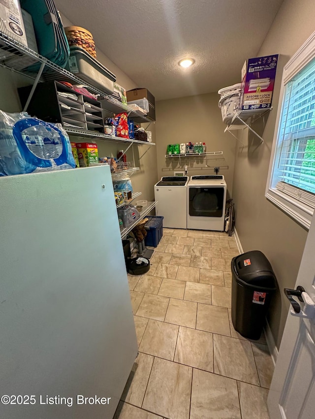 laundry room with laundry area, washing machine and clothes dryer, a textured ceiling, baseboards, and recessed lighting