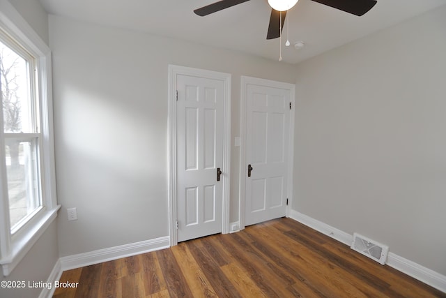 1024 Berry Blvd, Louisville, KY 40215 - unfurnished bedroom featuring dark wood-type flooring, baseboards, and ceiling fan