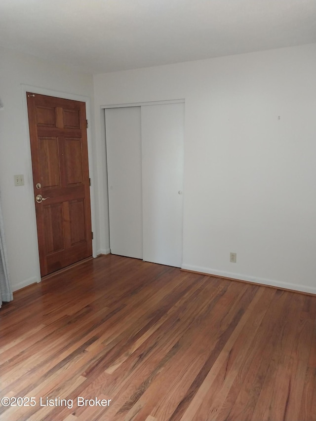unfurnished bedroom with light wood finished floors and a closet