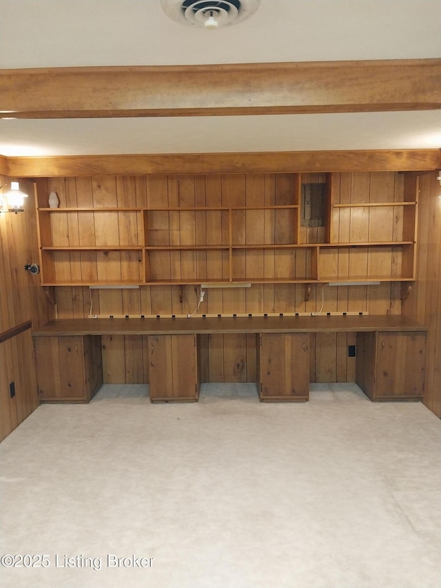 unfurnished office featuring wooden walls, carpet floors, and visible vents