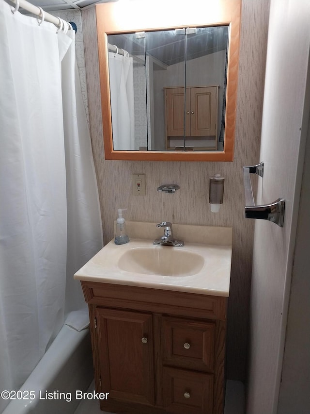 full bathroom featuring shower / bath combo with shower curtain, vanity, and wallpapered walls