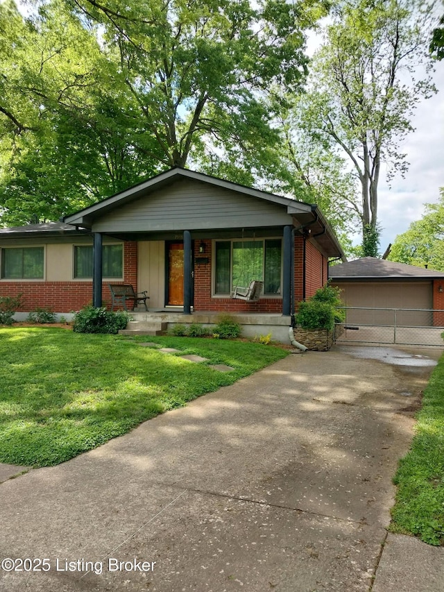 view of front of home featuring a porch, an outdoor structure, brick siding, driveway, and a front lawn