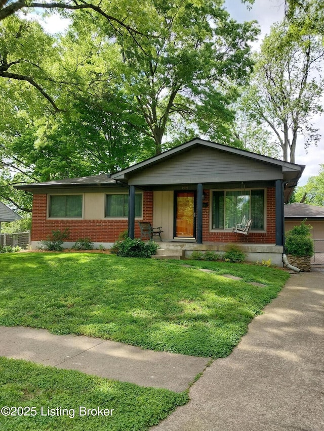 single story home with covered porch, a front lawn, and brick siding