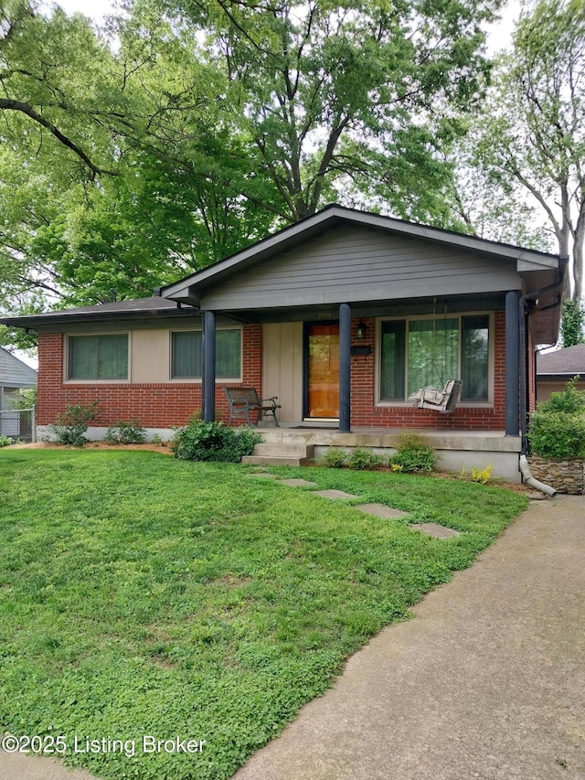 ranch-style home featuring a front lawn, brick siding, and covered porch