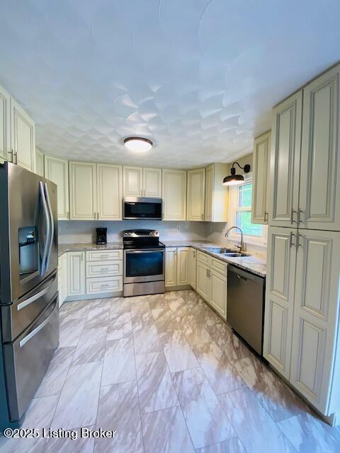 1300 Midway Ln, Springfield, KY 40069 - kitchen with stainless steel appliances, cream cabinetry, a sink, and light marble finish floors