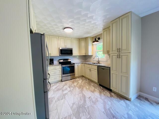 1300 Midway Ln, Springfield, KY 40069 - kitchen featuring stainless steel appliances, cream cabinetry, a sink, baseboards, and light marble finish floors