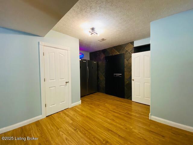 1300 Midway Ln, Springfield, KY 40069 - spare room with wood finished floors, a textured ceiling, and baseboards