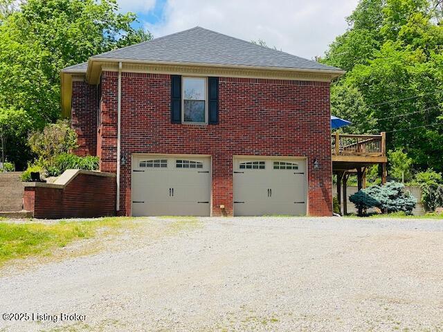 1300 Midway Ln, Springfield, KY 40069 - view of side of property featuring an attached garage, brick siding, driveway, and a deck