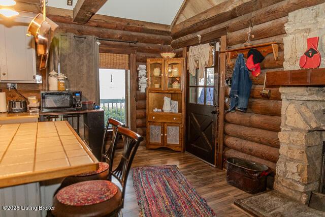 interior space featuring rustic walls, wood finished floors, and high vaulted ceiling