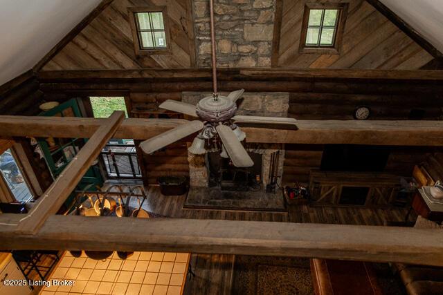 interior details featuring a ceiling fan and log walls