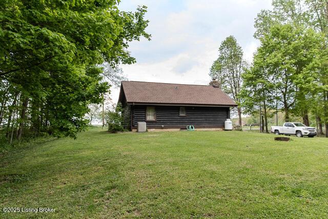 exterior space featuring a chimney and a lawn