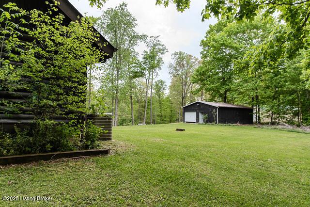 view of yard featuring a garage and an outbuilding