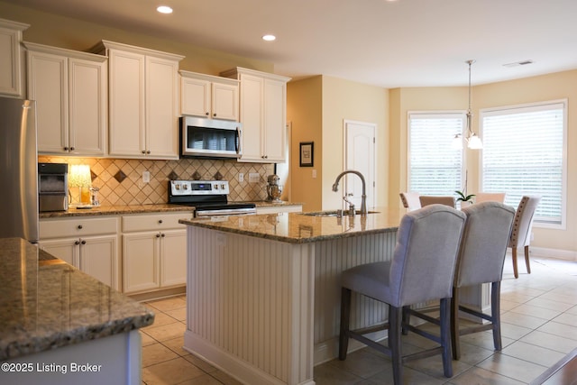 803 Urton Woods Way, Louisville, KY 40243 - kitchen with stainless steel appliances, a sink, tasteful backsplash, a breakfast bar area, and recessed lighting
