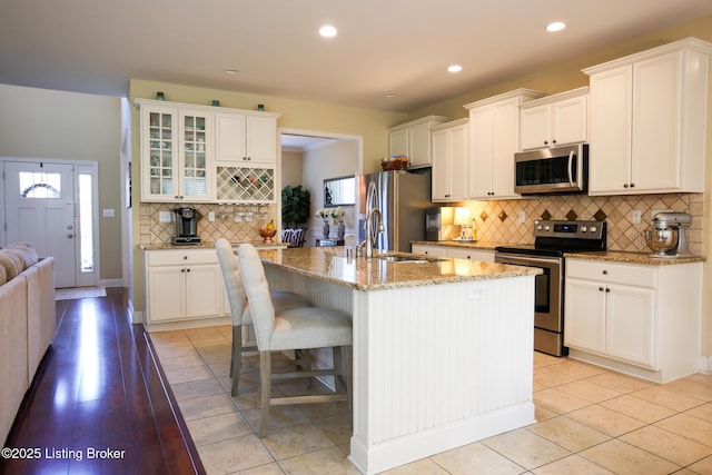 803 Urton Woods Way, Louisville, KY 40243 - kitchen featuring appliances with stainless steel finishes, a sink, decorative backsplash, light stone countertops, and a kitchen breakfast bar