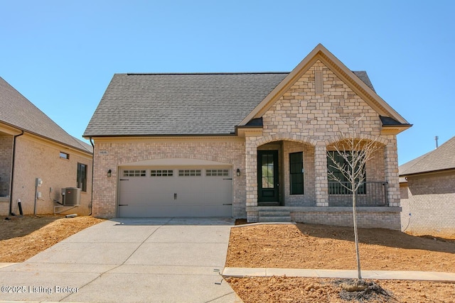 view of front of house with a porch, central air condition unit, an attached garage, brick siding, and concrete driveway