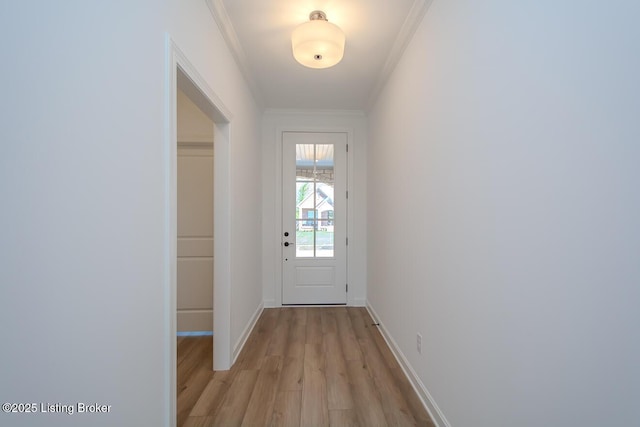 entryway featuring ornamental molding, light wood-style floors, and baseboards