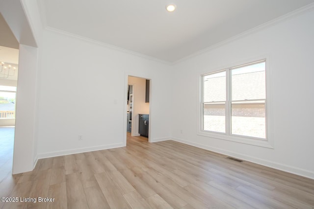 spare room featuring ornamental molding, a notable chandelier, light wood-style flooring, and visible vents